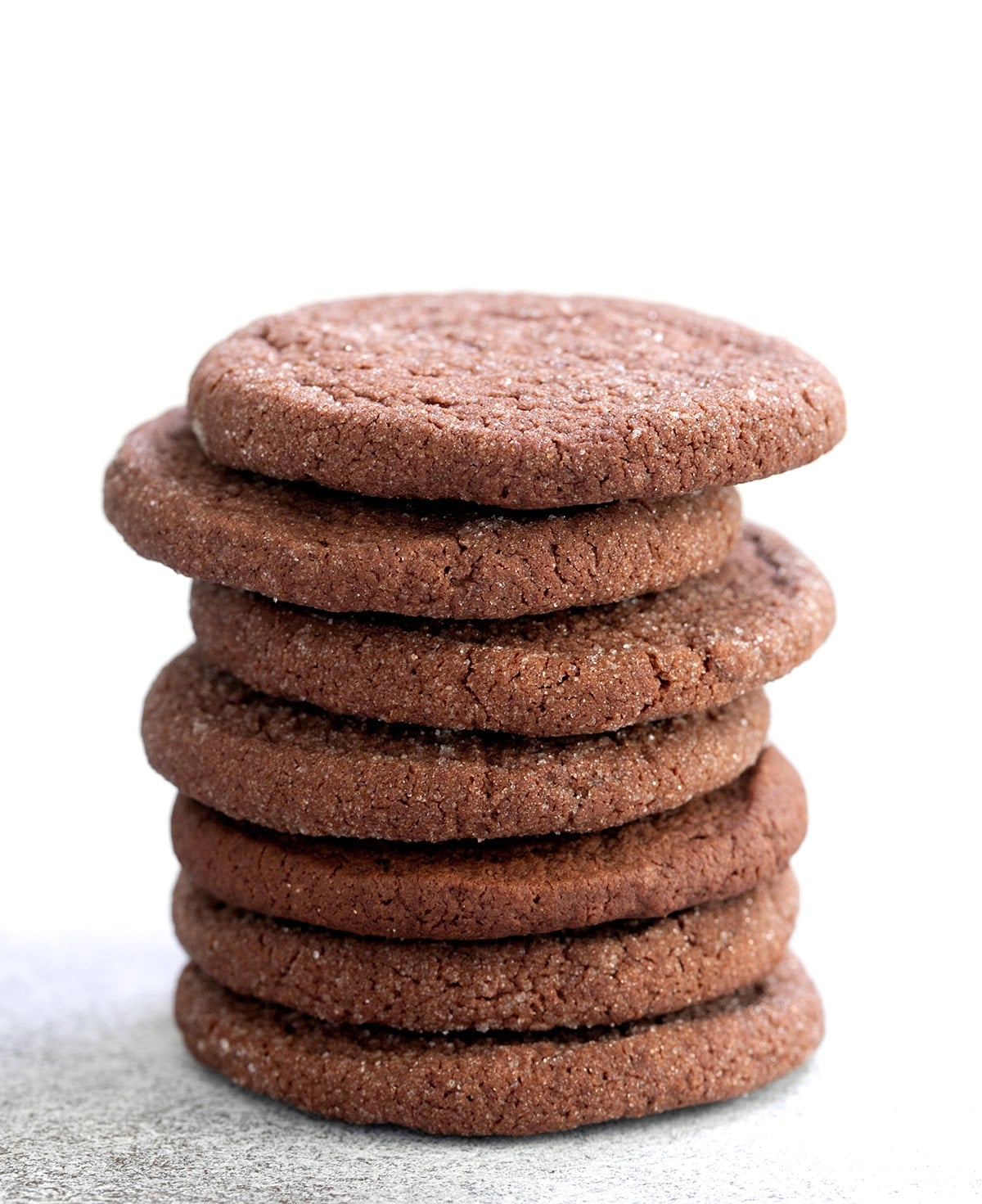 7 brown chocolate cookies with sugar coating in tall stack