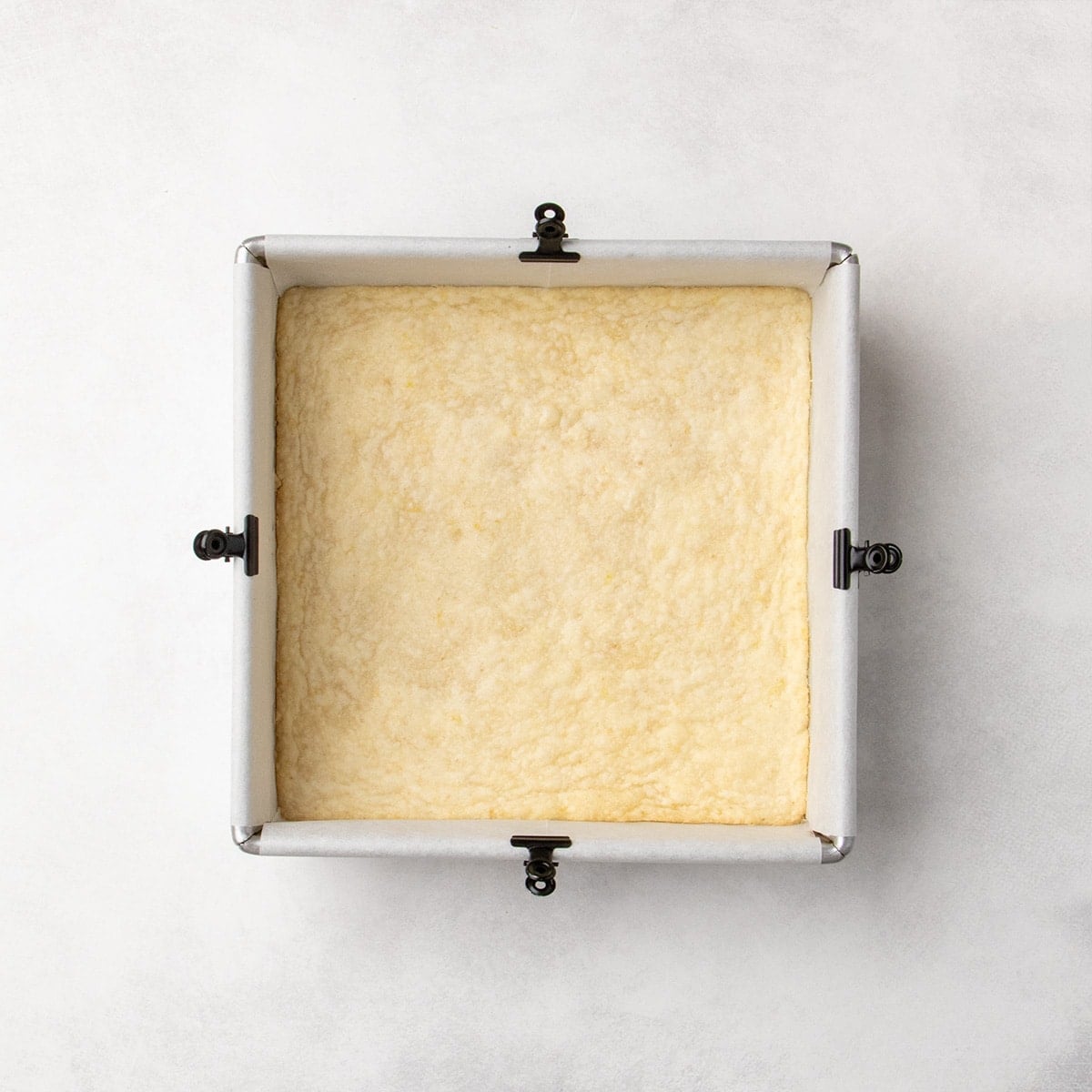 Baked pale yellow crust in a square pan, with very lightly golden color on the edges.