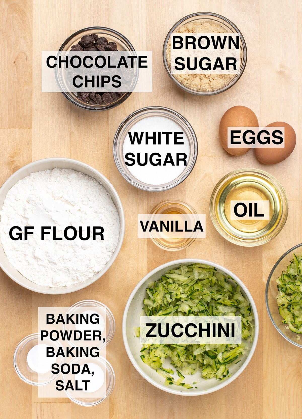 Ingredients required to make the recipe prepared in round glass and ceramic bowls on light wood surface. 