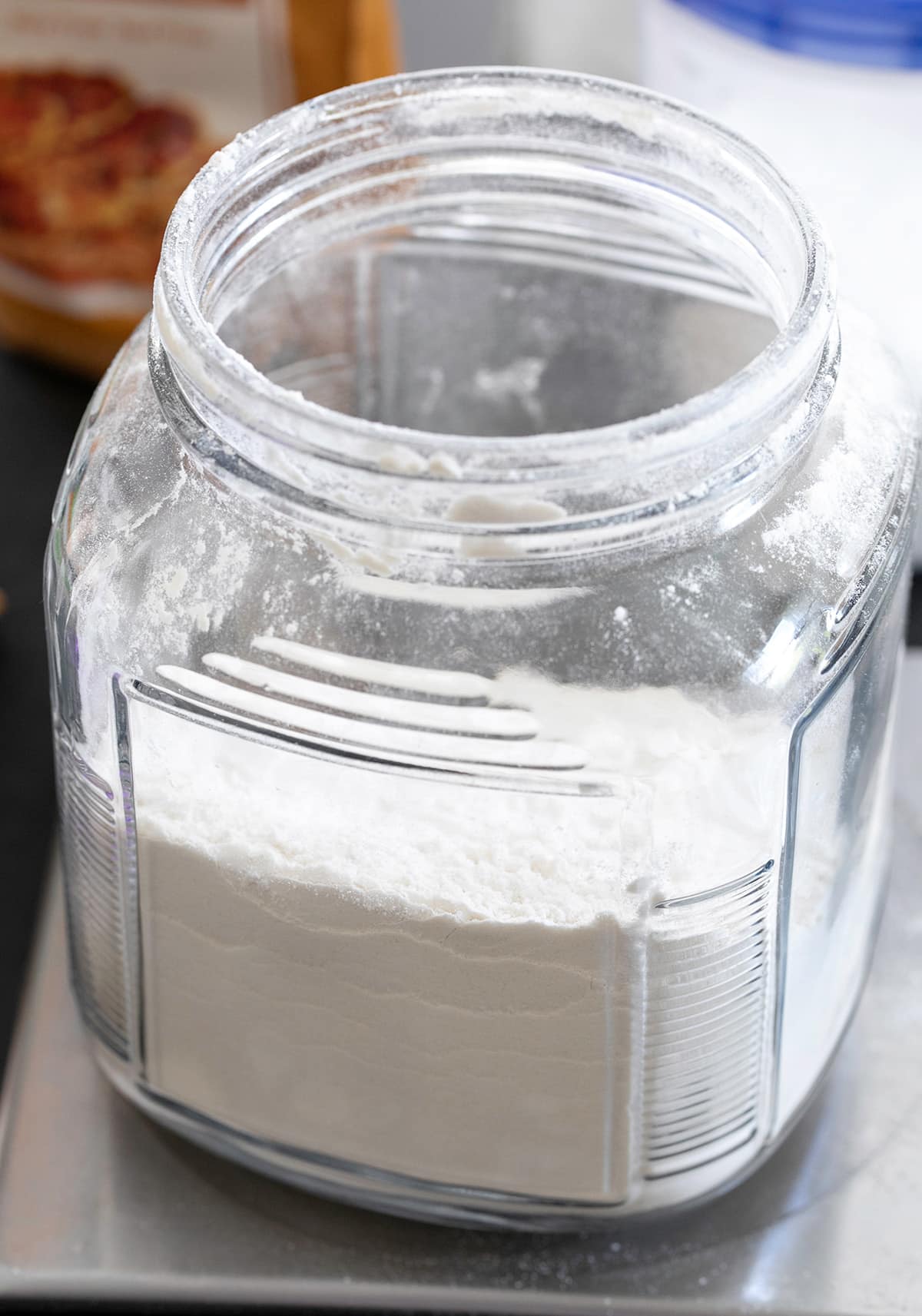 closeup image of white powder gluten free flour in open jar