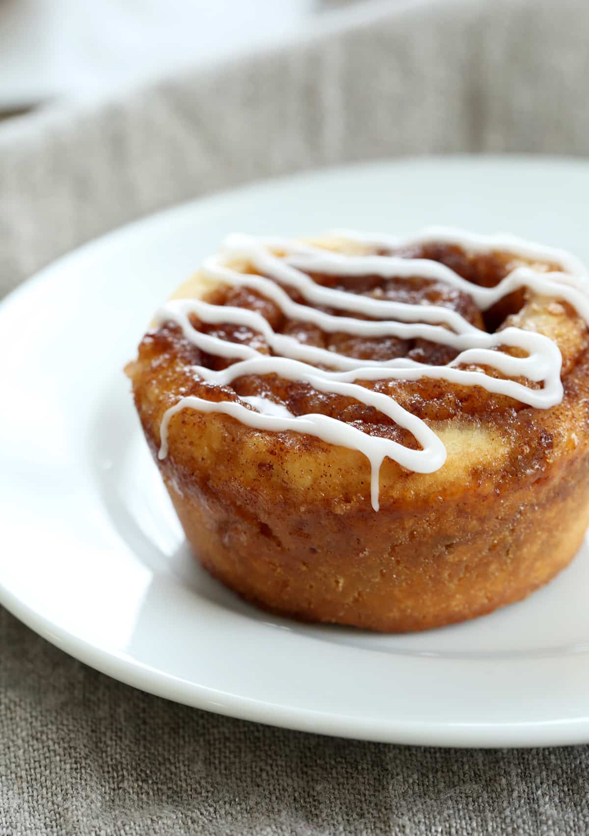 A close up of a cinnamon bun on a white plate