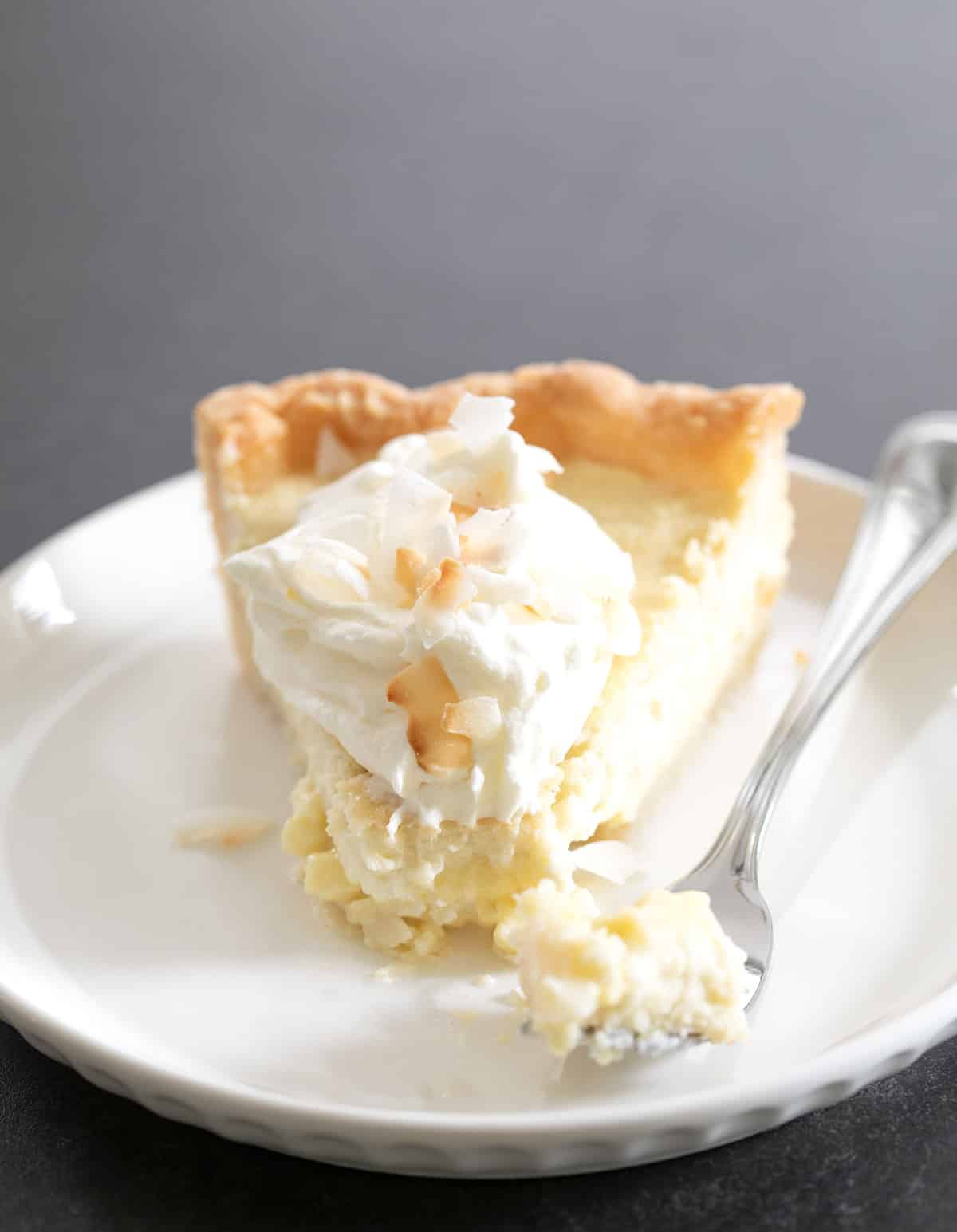 A single slice of the pie on a plate with a fork next to it.