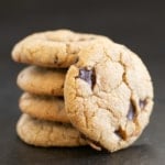 closeup on stack of 5 chocolate chip cookies with one in front on dark background