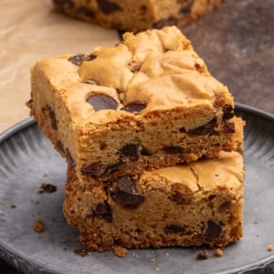 Closeup of stack of 2 square gluten free cookie bars with chocolate chips on small round gray plate