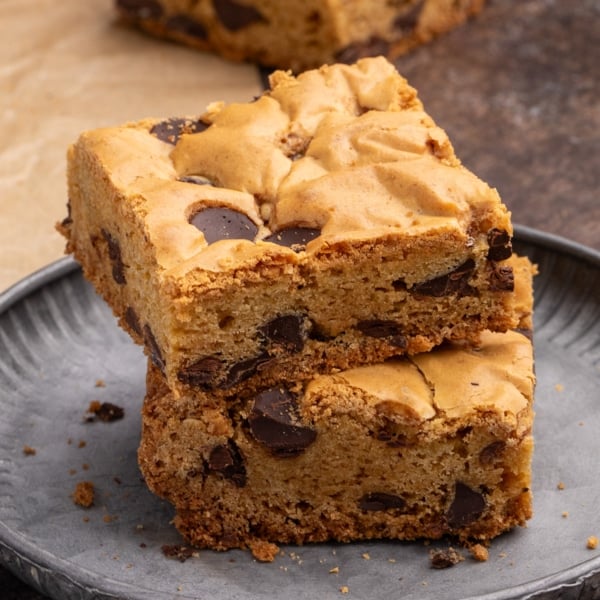 Closeup of stack of 2 square gluten free cookie bars with chocolate chips on small round gray plate