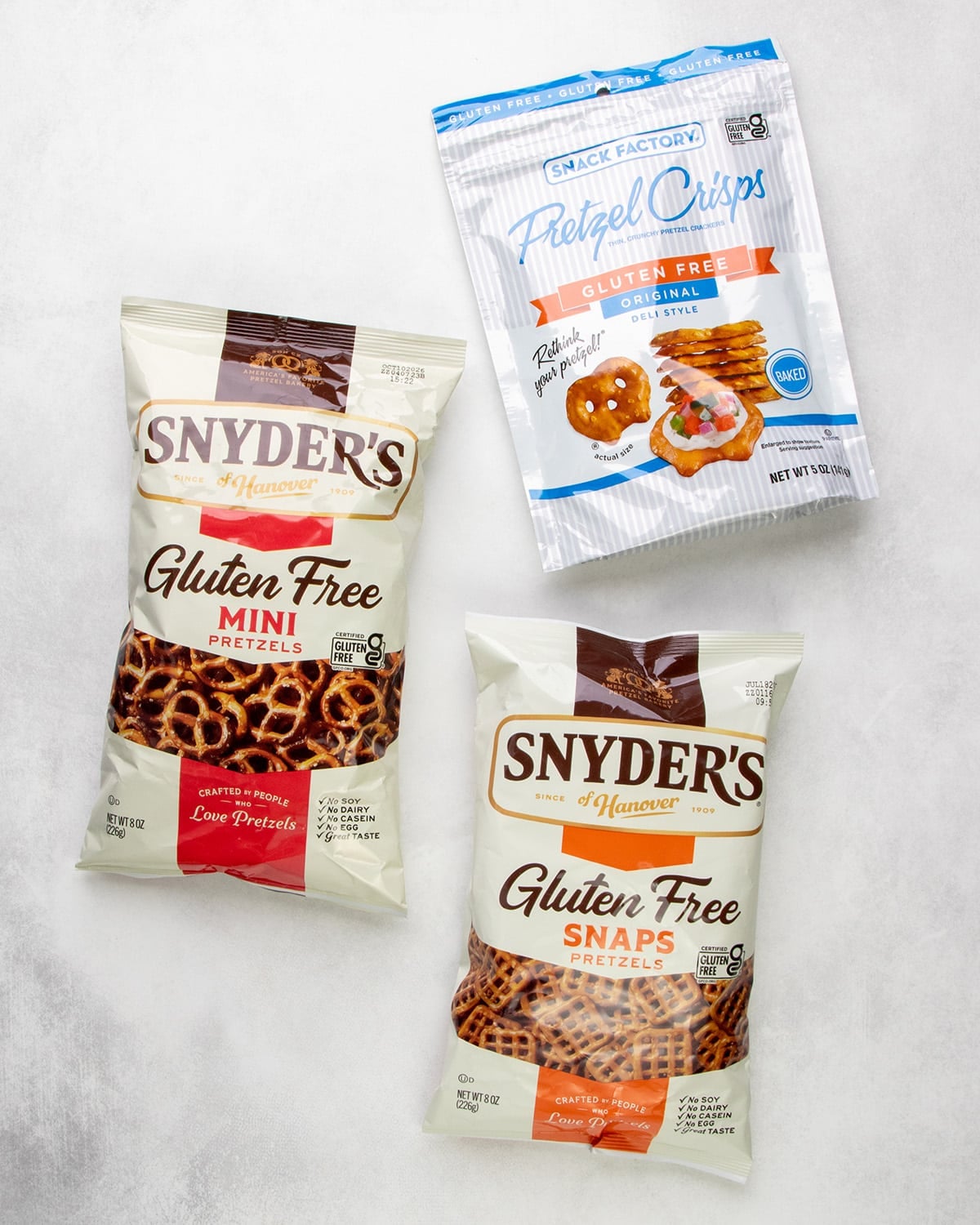Packages of Snyder’s gluten free mini pretzels, Snyder’s gluten free snaps pretzels, and Snack Factory gluten free pretzel crisps.