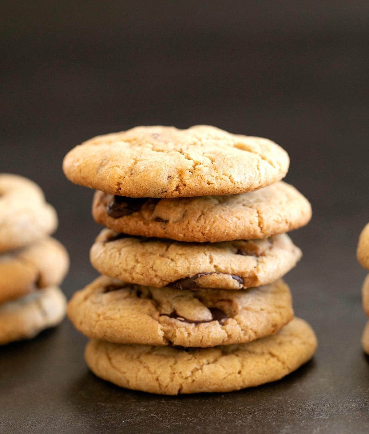 Mrs. Fields Chocolate Chip cookies in a stack of 5 cookies on a dark background