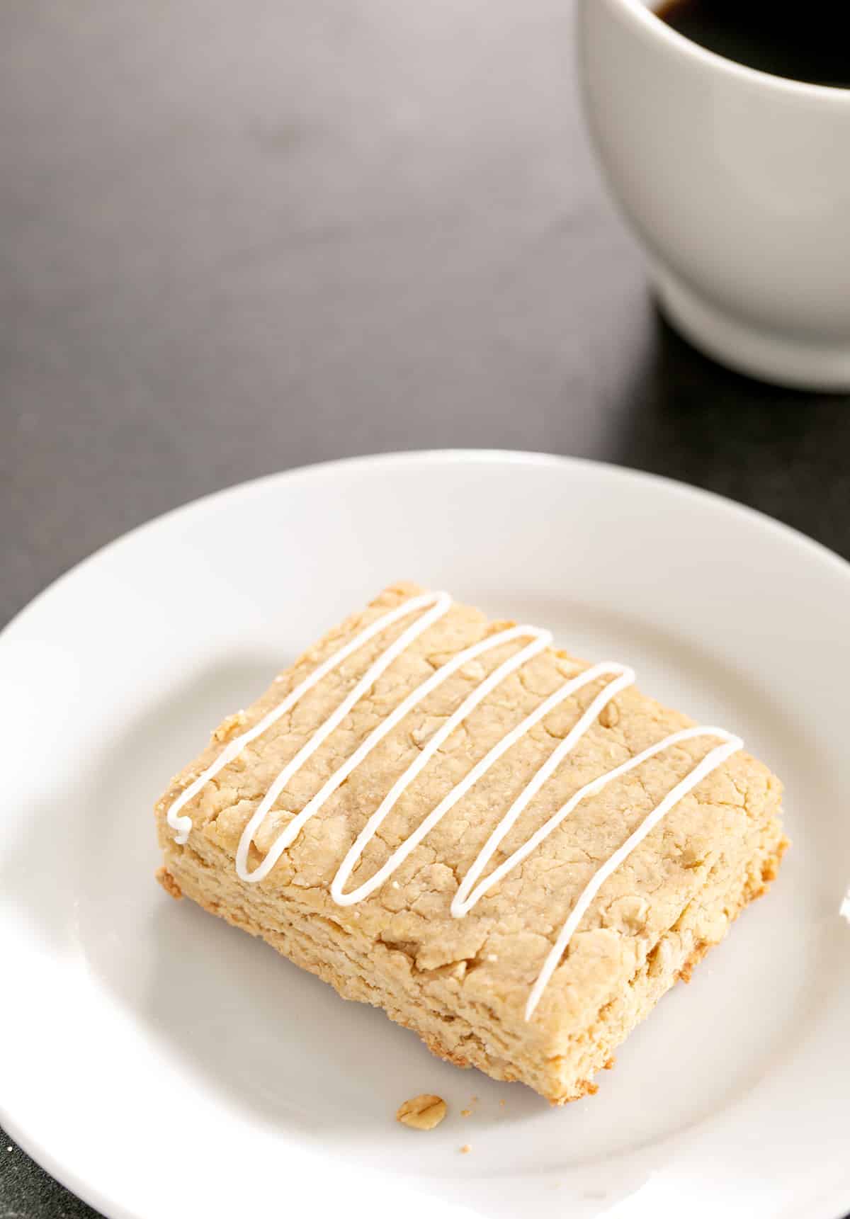 Oatmeal bar on a small plate with a cup of coffee