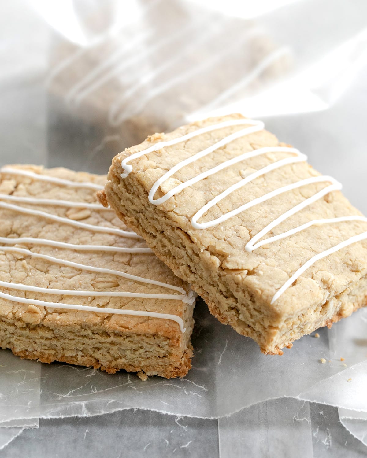 Oatmeal bars on a wax paper bag and inside the bag