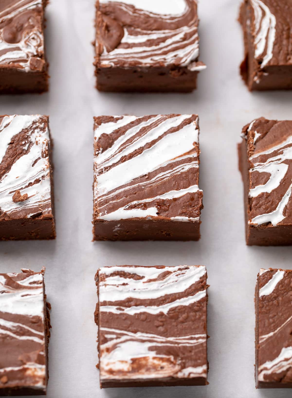 9 square pieces of fudge evenly spaced with white swirls on top on white paper