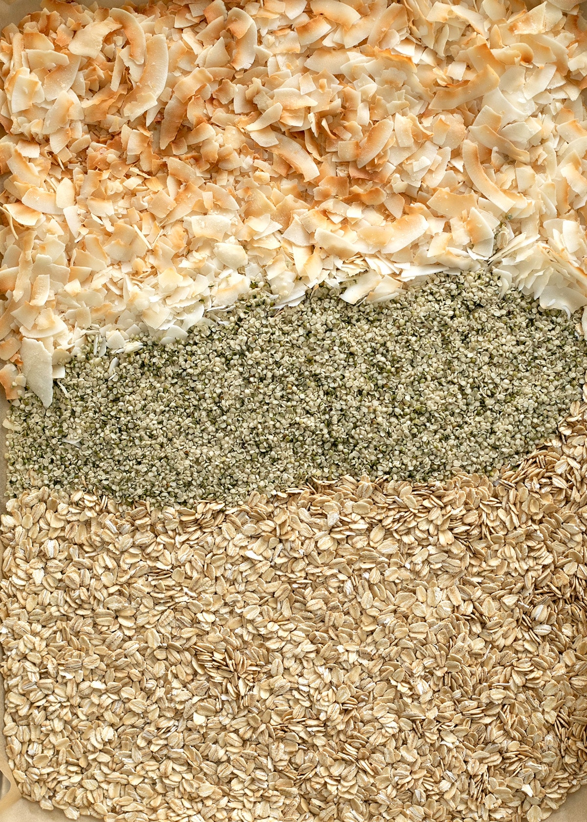 ingredients for protein balls being toasted on baking sheet