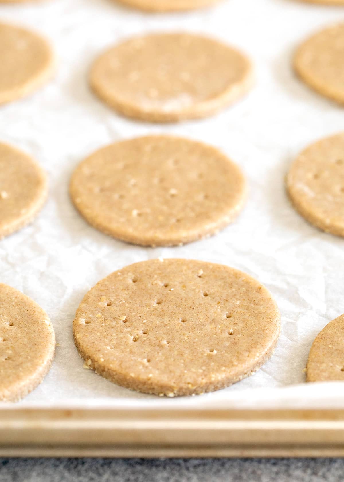 Raw shaped digestive biscuits on white paper on a tray