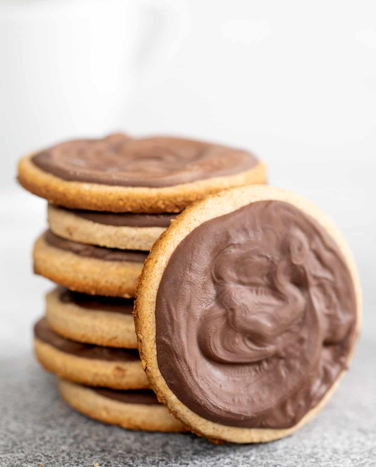 Stack of chocolate covered digestive biscuits with one on its side leaning against the stack
