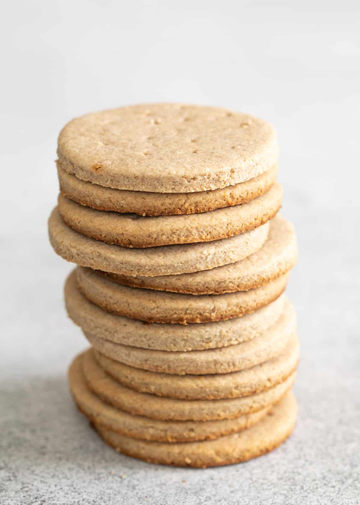 Tall stack of digestive biscuits on a white surface