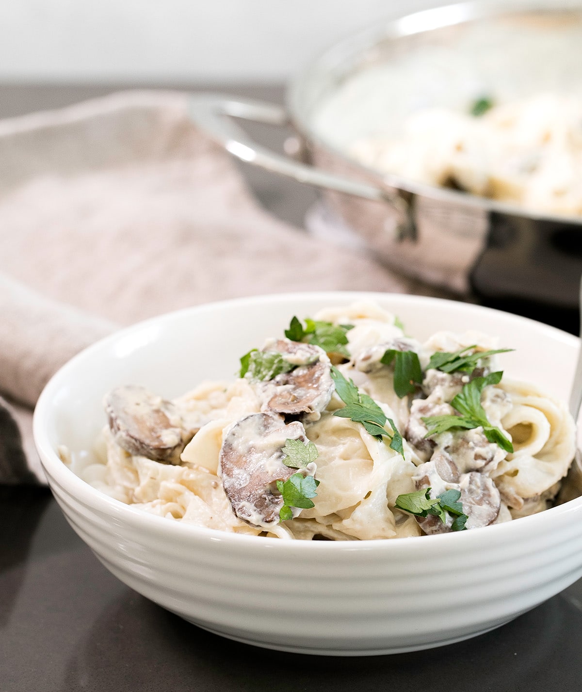 A white bowl with the sauce and pasta.