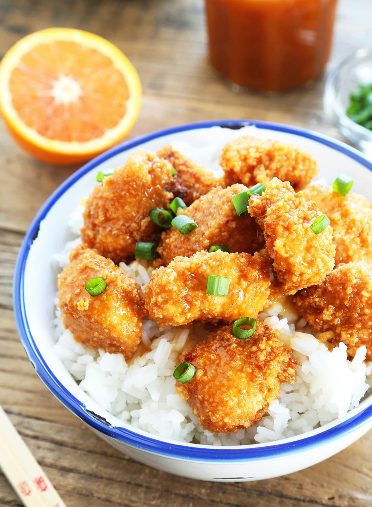 Overhead view of Chinese-style orange chicken with rice in a white bowl