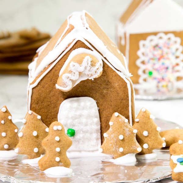 closeup image of gluten free gingerbread house fully decorated with white royal icing and a green sixlet candy as a doorknob