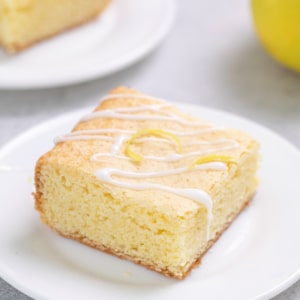 closeup on light yellow colored gluten free lemon brownie square on small white plate