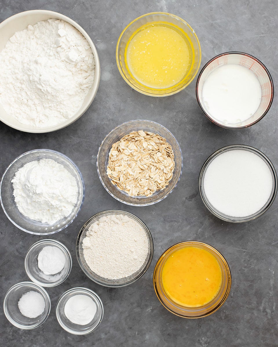 Ingredients for gluten free oat bread in small glass and ceramic bowls