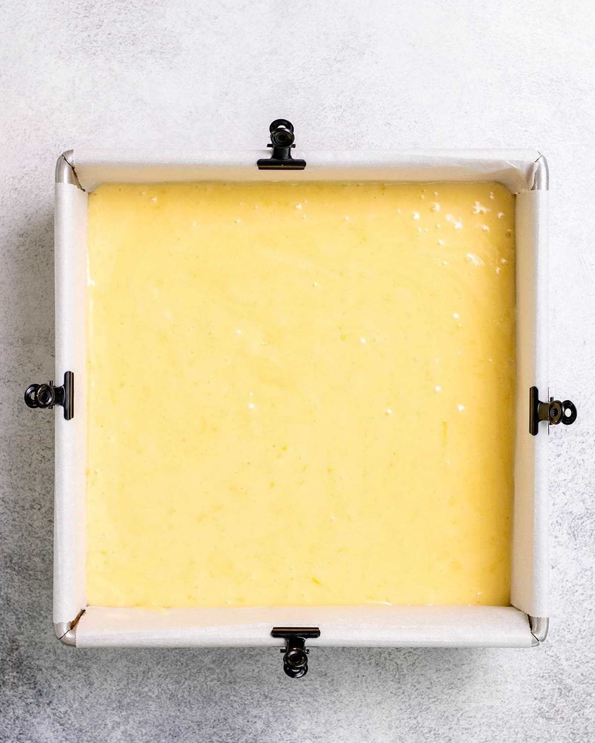 Overhead image of raw lemon brownie batter in square pan