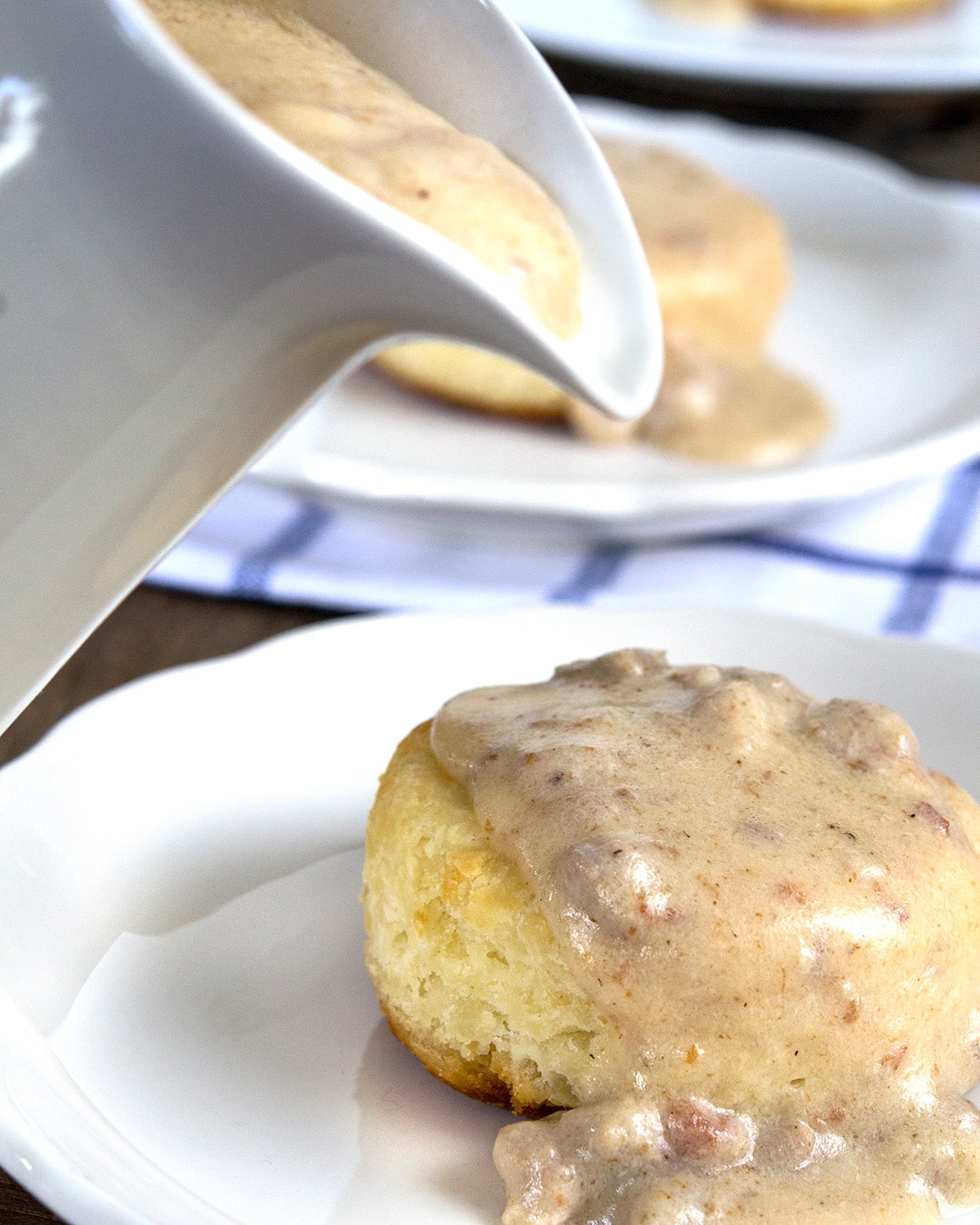 Gluten Free Biscuits and Gravy Close up of gravy being poured on biscuit.