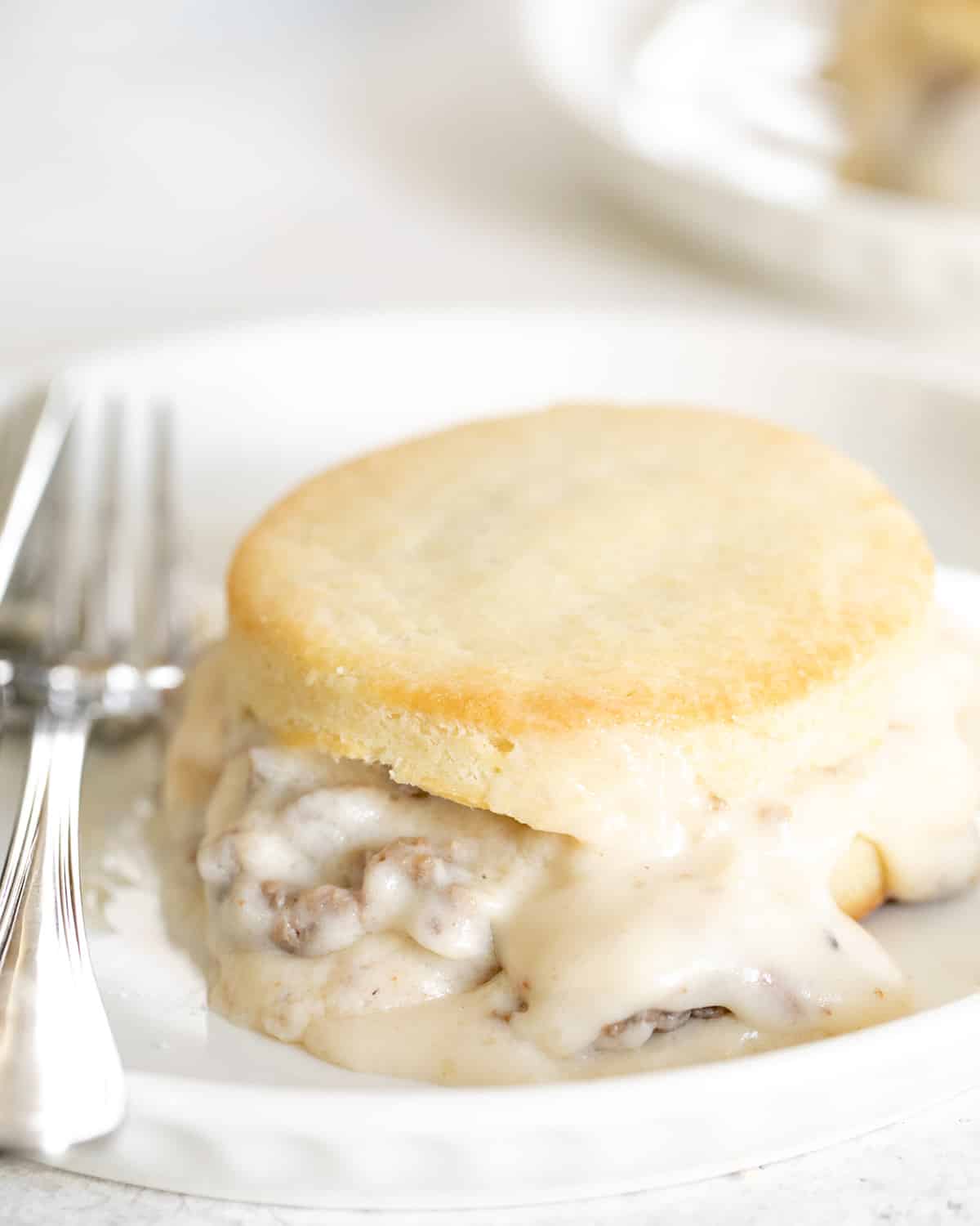 A close up of a finished biscuit on a plate with a fork.