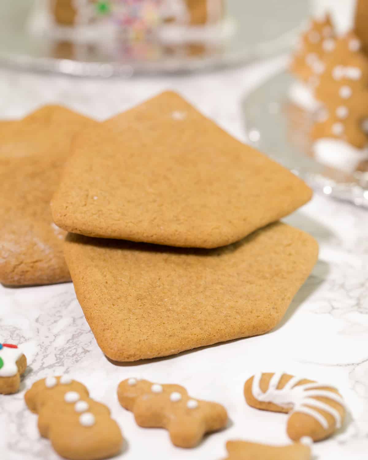 3 house shaped gingerbread cookies on marble surface