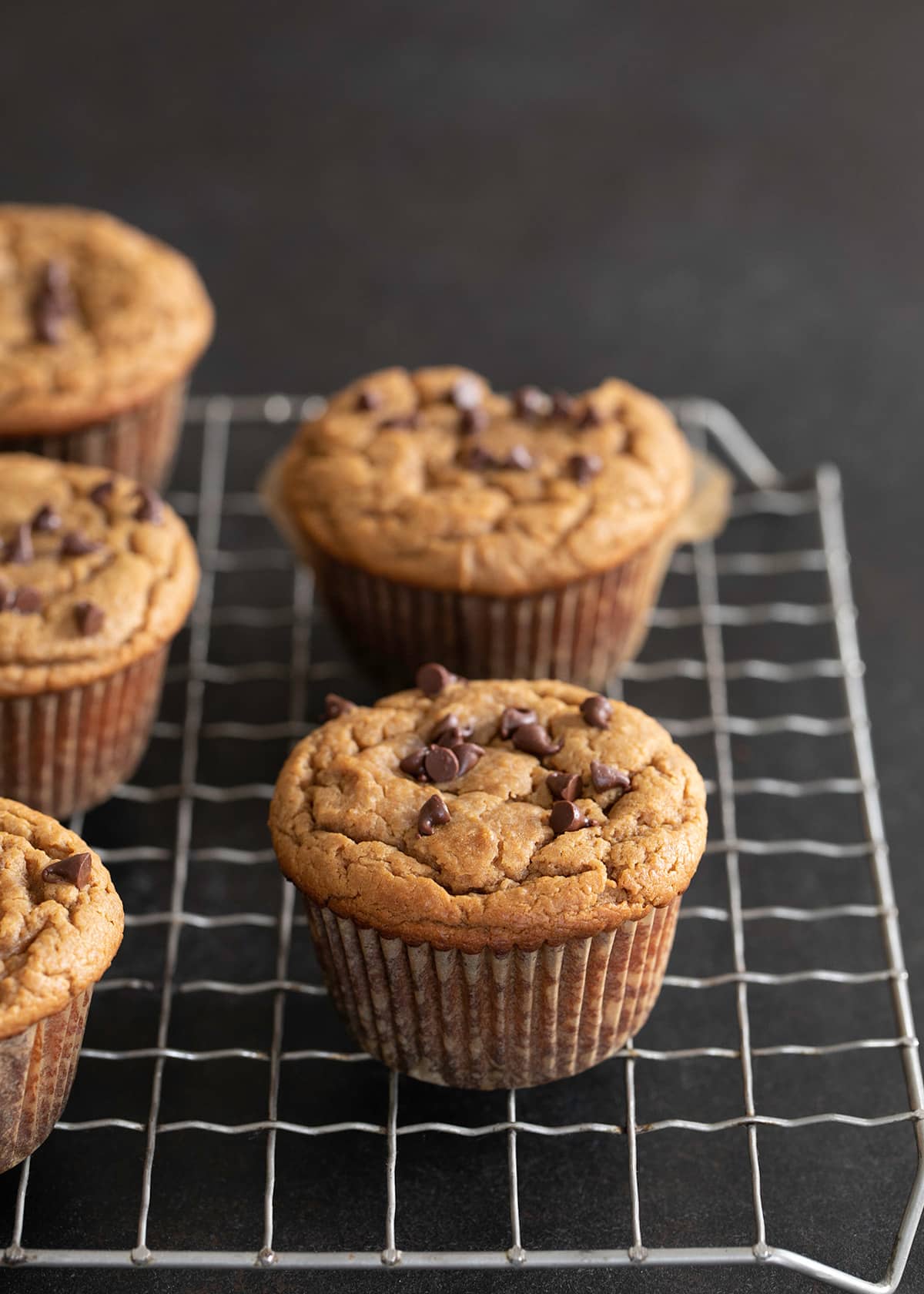 Flourless peanut butter muffins whole muffins on a wire rack.