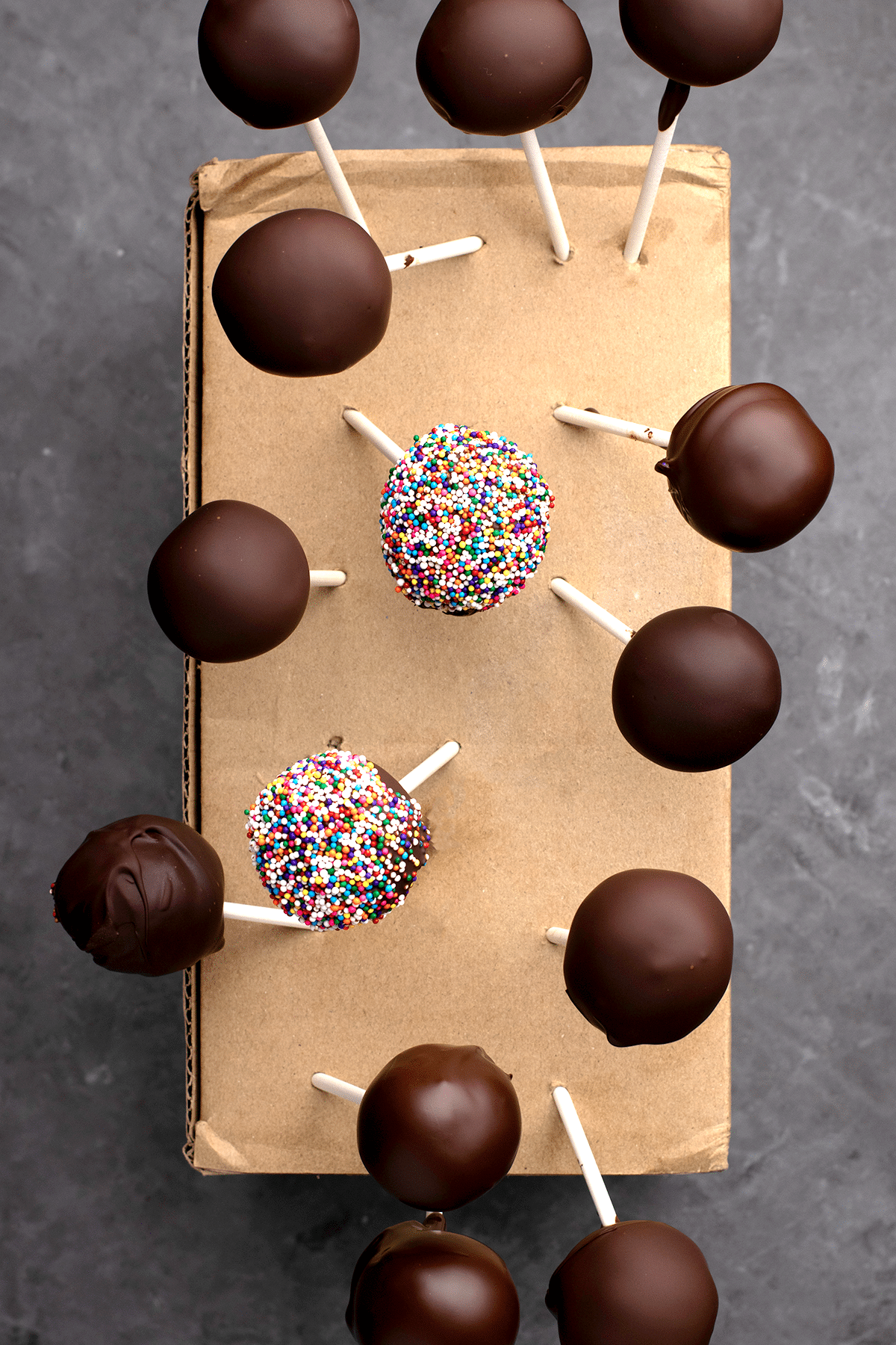 Overhead image of chocolate covered cake pops in cardboard box