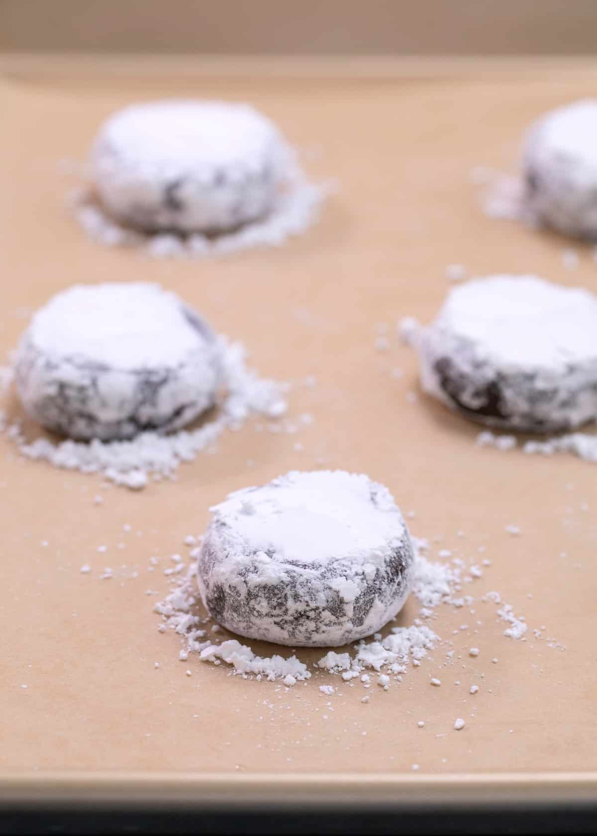 Raw chocolate crinkle cookie dough shaped with confectioners' sugar